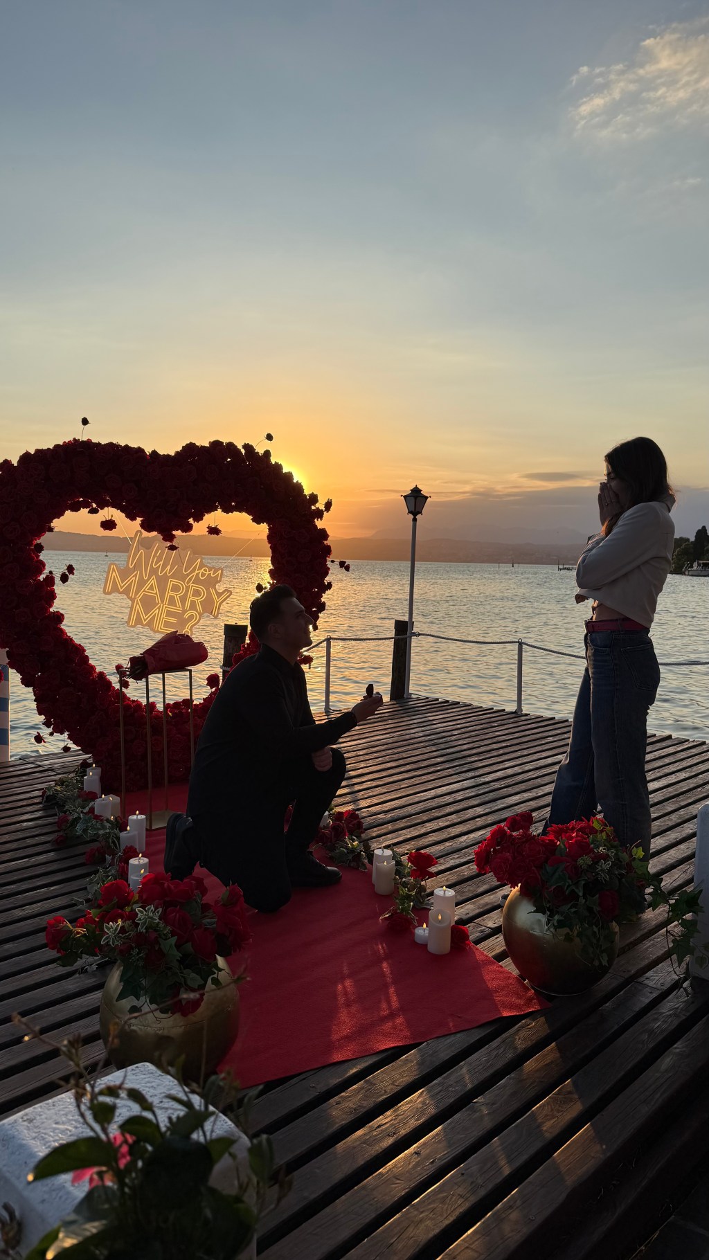 Luxury surprise proposal setup on a private pier in Lake Garda at sunset